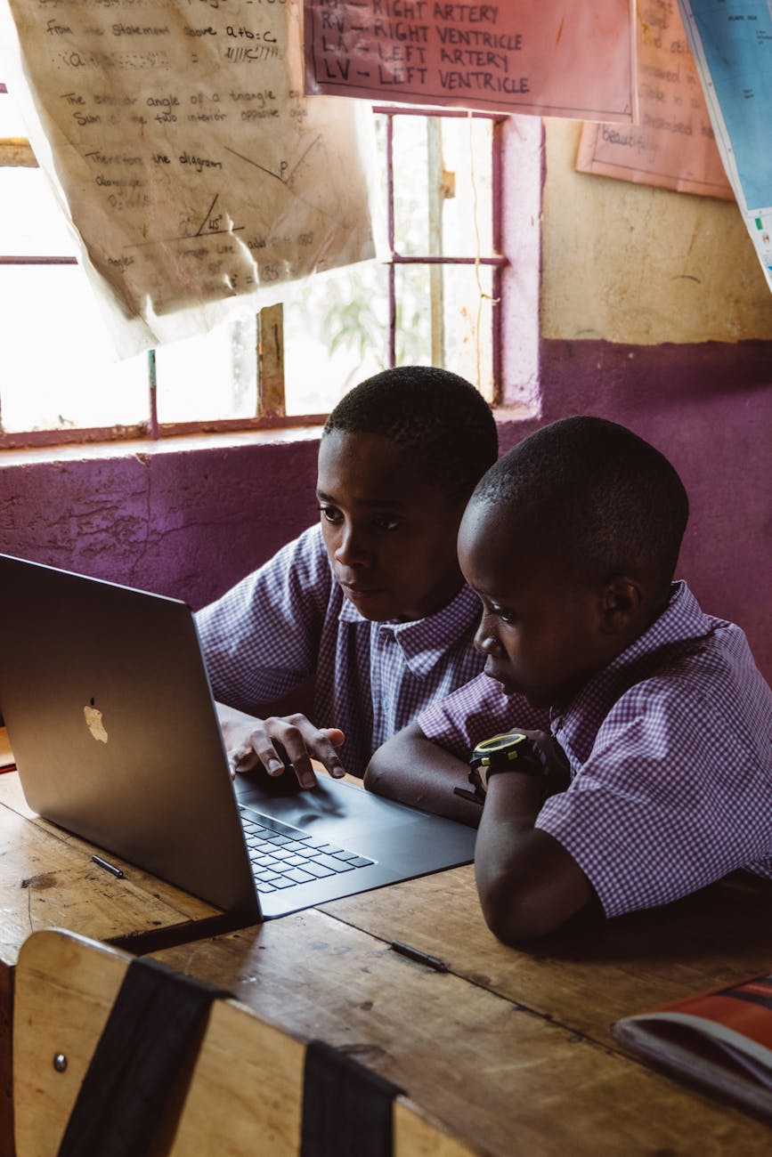 young boys using laptop while studying